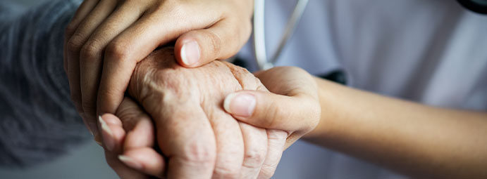 Nurse hands holding a patient's hand